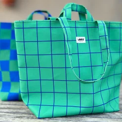 Bolsa grande de color verde con líneas a cuadros de color azul